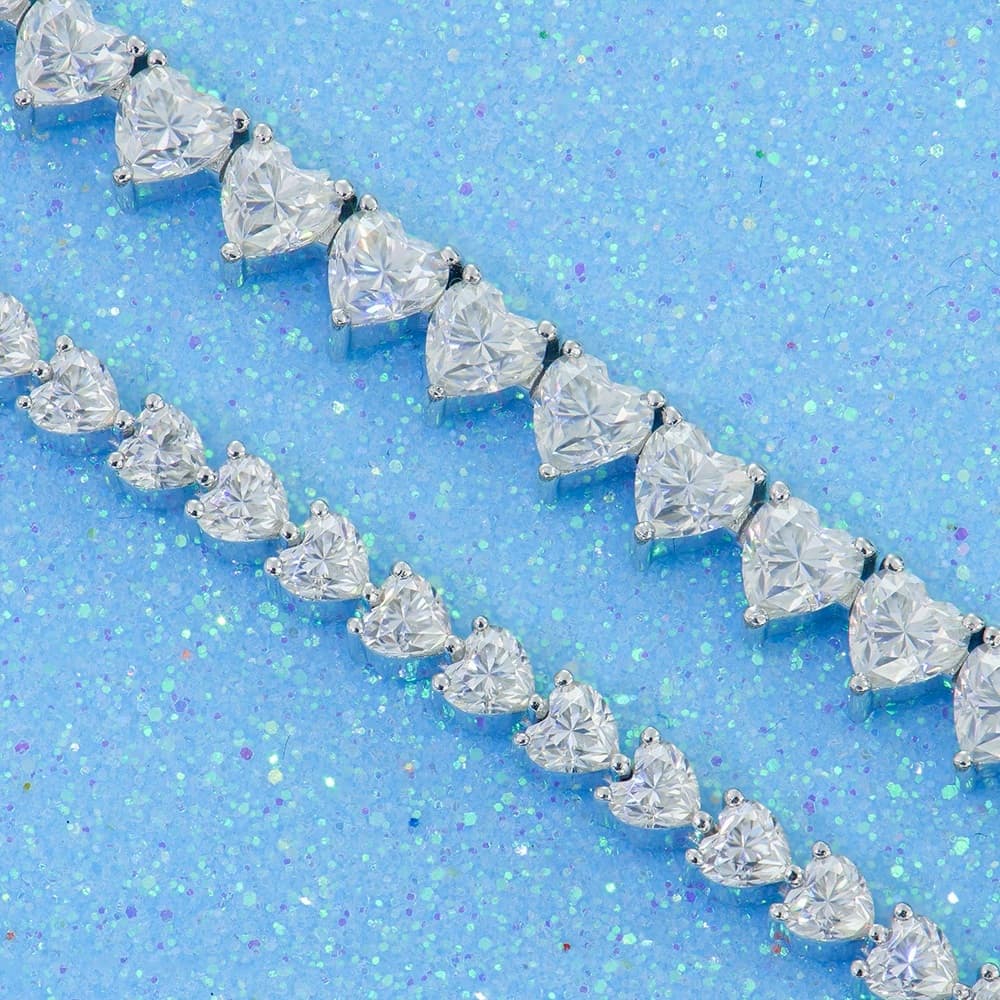 Heart cut tennis chain jewelry on a blue surface
