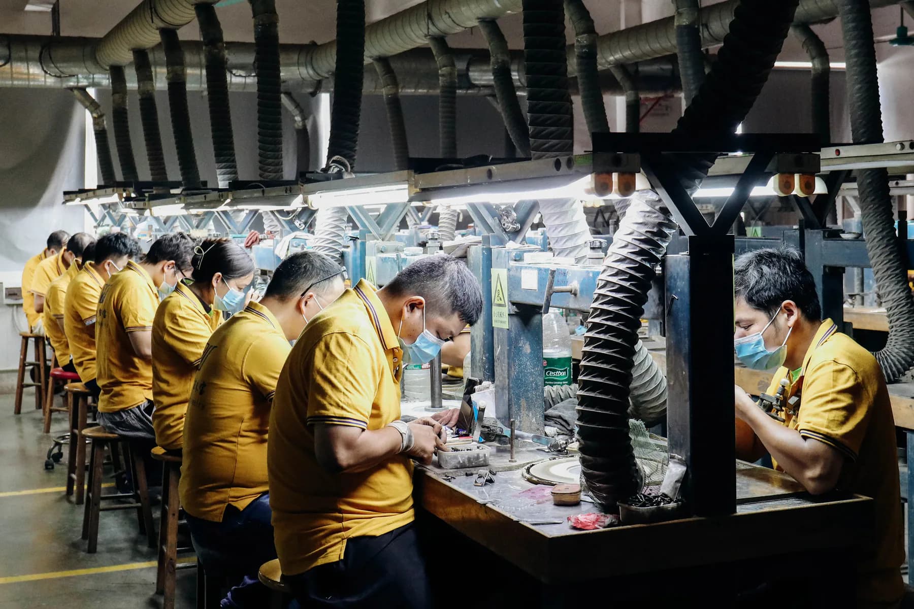 Jewelry artisans working at setting benches in a Wuzhou workshop