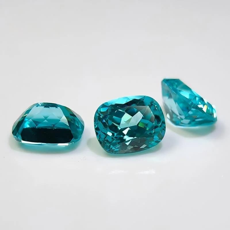 Blue lab-grown gemstones in mixed cuts on a white background