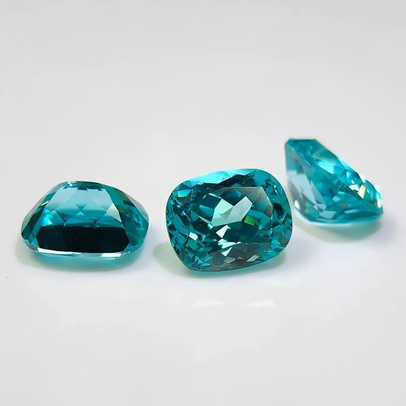 Blue lab-grown colored gemstones in mixed cuts on a white background