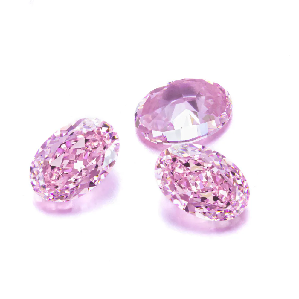 Pink lab-grown colored gemstones in mixed cuts on a white background